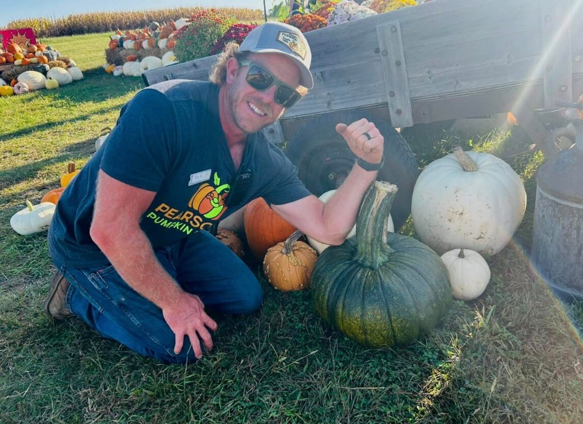 Pearson Pumpkin Place owner showing that pumpkin stem is as thick as his arm